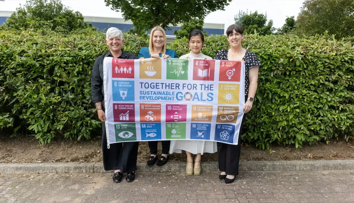 4 people holding a flag